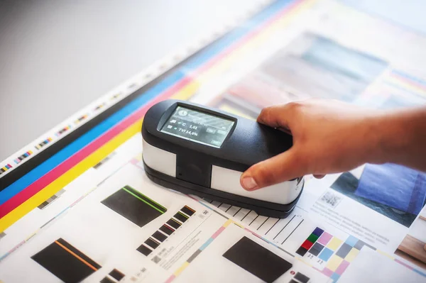 stock image X-Rite handheld spectrophotometer verify color patches, modern press shop prepress department.