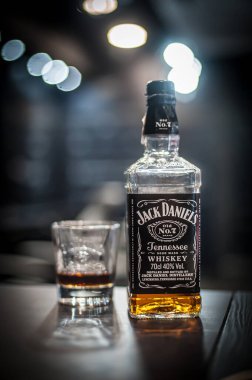 Jack Daniels viskisi - Belgrad, Sırbistan Octobar 2022 - Bir şişe Jack Daniels viskisi ve bardağı ahşap masanın üzerinde, odak arkaplanı bulanık. Amerikan viskisinin markası.