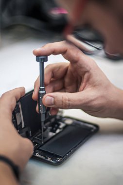 Servis merkezinde cep telefonu onarımı, akıllı telefon sökülmesi ve teşhisi, tamirci işyeri üst görünümü