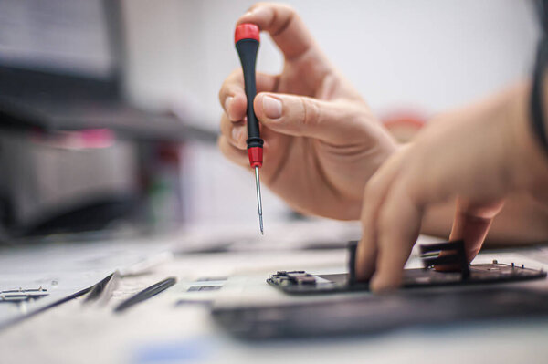 Cell phone repair at service center, smartphone disassembling and diagnostics, repairman workplace top view