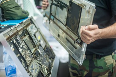 Close-up of specialized manual cleaning of laptop, screen, notebook, keyboard, case, from dust. Cleaning accessories: small vacuum cleaner, brush, cloth, spray.. Technical support and solving problems with gadgets. It is the service and maintenance o