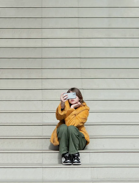 Молодая Красивая Женщина Жёлтой Шубе Влиятельная Личность Соцсетях Сидит Лестнице — стоковое фото