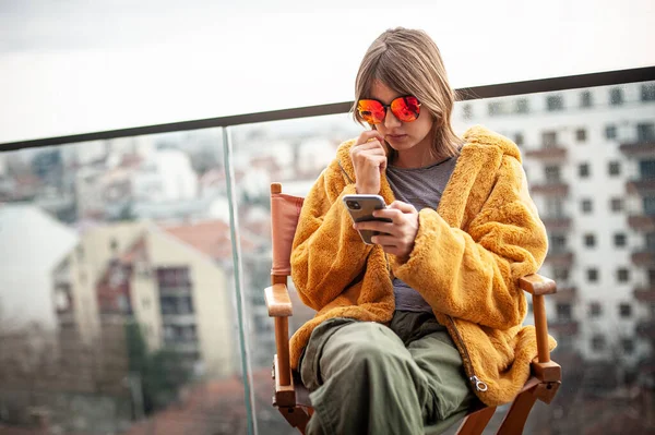 Die Schöne Junge Frau Gelbem Pelzmantel Und Roter Sonnenbrille Sitzt — Stockfoto