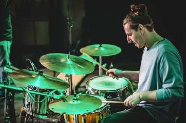 Davul müzik grubu davulcusu sahnede canlı performans sergiliyor. Tekrarlama ve uygulama