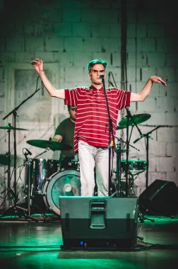 Punk rock müzik grubu. Şarkıcı bir sahnede canlı performans sırasında yakın çekim portresi yapıyor. 