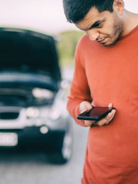 Genç bir sürücü yolda bir araba arızası yaşadı. Cep telefonuyla yol yardımı araba tamircisini arayıp bulmaya çalışıyor. Kaput açık ve arabanın motoru bozuk.