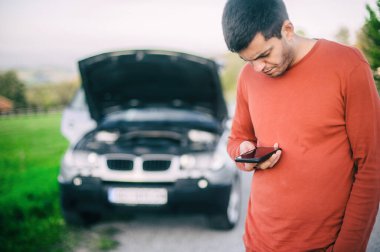 Genç bir sürücü yolda bir araba arızası yaşadı. Cep telefonuyla yol yardımı araba tamircisini arayıp bulmaya çalışıyor. Kaput açık ve arabanın motoru bozuk.