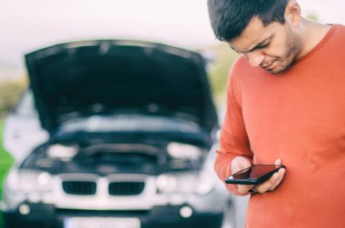 Genç bir sürücü yolda bir araba arızası yaşadı. Cep telefonuyla yol yardımı araba tamircisini arayıp bulmaya çalışıyor. Kaput açık ve arabanın motoru bozuk.