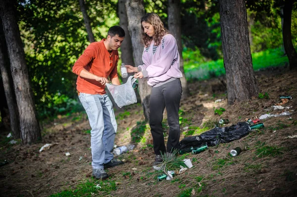 年轻夫妇收集扔在自然公园里的垃圾 维护和保护生态环境 废物对环境的影响 — 图库照片