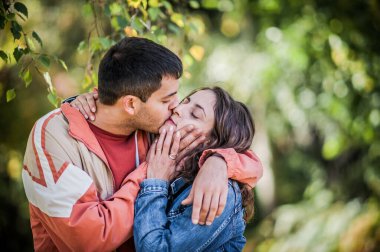 Romantik çift parkta sarılıp öpüşüyor. İlişki ve romantizm kavramı