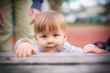 Çocukluğun masumiyetini ve mucizesini yakalayan tuhaf bir görüntü. Küçük bir çocuk sihirli bir masanın üzerine eğiliyor, merak ve beklenti yayıyor.