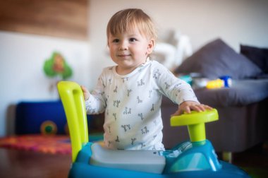 Sevimli, mutlu bebek çocuk renkli oyuncak kamyonuyla oturma odasında oynuyor. Neşe ve mutluluk kavramı. Aşk ve aile duyguları