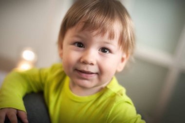 Saf mutluluk saçan, oyun saatinde rahat bir evde mutlu, şirin bir bebeğin ışıltılı gülümsemesi. Aşk ve aile kavramı