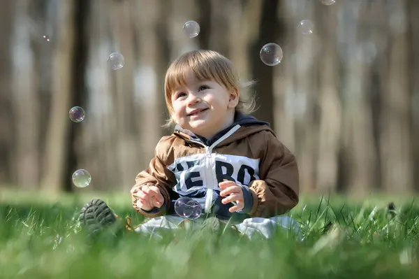 Ευτυχισμένο Χαμογελαστό Χαριτωμένο Απολαύσεις Νήπιο Στο Κυνήγι Κυμαινόμενο Σαπουνόφουσκες Λουσμένο Εικόνα Αρχείου
