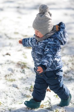 Güzel bir kış günü dışarıda karda oynayan sevimli, gülen çocuk. Doğayı keşfeden çocuk. Küçük çocuklar için kış aktiviteleri