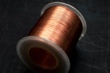 spool of copper wire on a black background