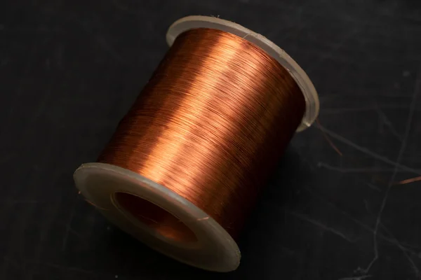 spool of copper wire on a black background
