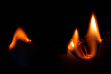 Yanan kağıt, parlayan kağıt kenarı siyah arkaplan üzerinde