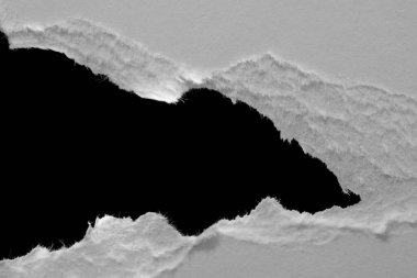 Siyah zemin üzerinde yırtık beyaz bir kağıt tabakasının kenarı, kara delik