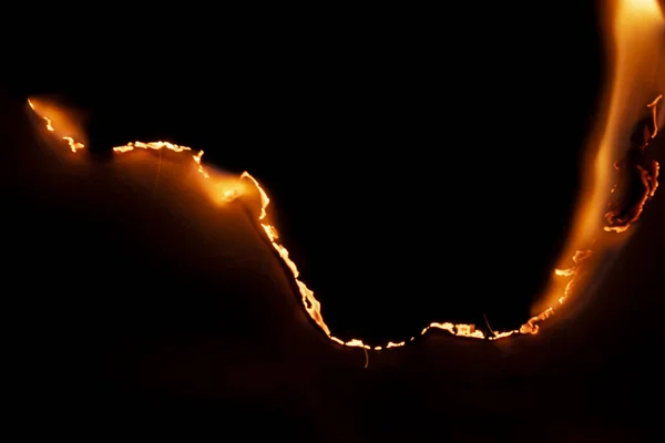 Yanan kağıt, parlayan kağıt kenarı siyah arkaplan üzerinde