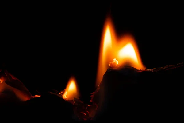 burning paper, glowing edge of paper on a black background