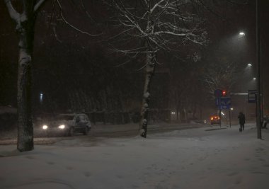 Şehirde kış mevsimi. Sokaklar ve arabalar karla kaplı.