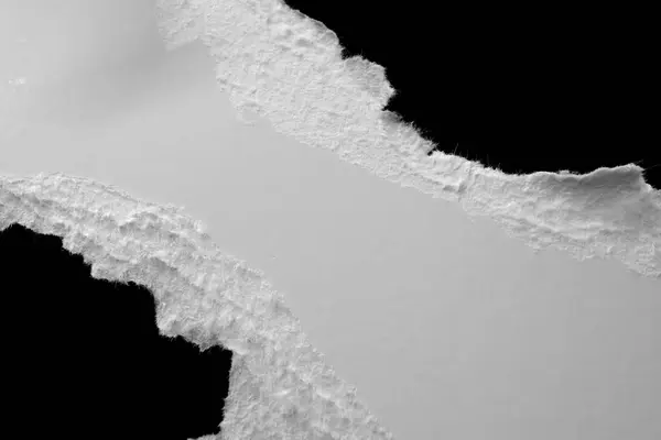 Siyah zemin üzerinde yırtık beyaz bir kağıt tabakasının kenarı, kara delik