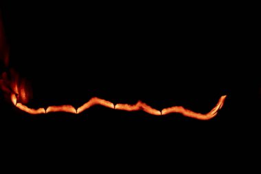 Yanan kağıt, parlayan kağıt kenarı siyah arkaplan üzerinde