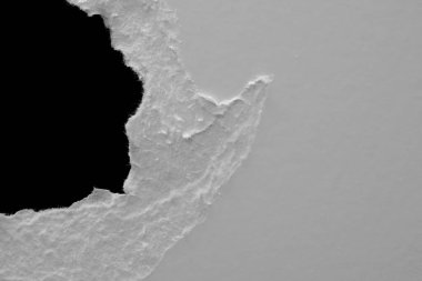 Siyah zemin üzerinde yırtık beyaz bir kağıt tabakasının kenarı, kara delik