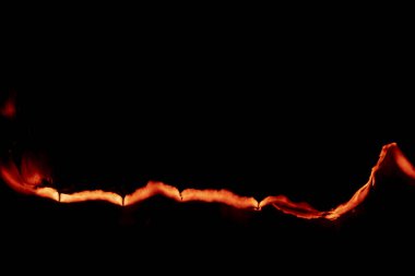 Yanan kağıt, parlayan kağıt kenarı siyah arkaplan üzerinde