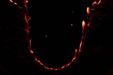 Yanan kağıt, parlayan kağıt kenarı siyah arkaplan üzerinde