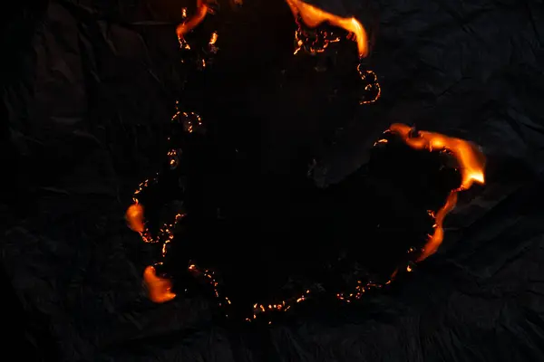 Yanan kağıt, parlayan kağıt kenarı siyah arkaplan üzerinde