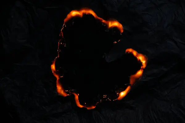 Yanan kağıt, parlayan kağıt kenarı siyah arkaplan üzerinde
