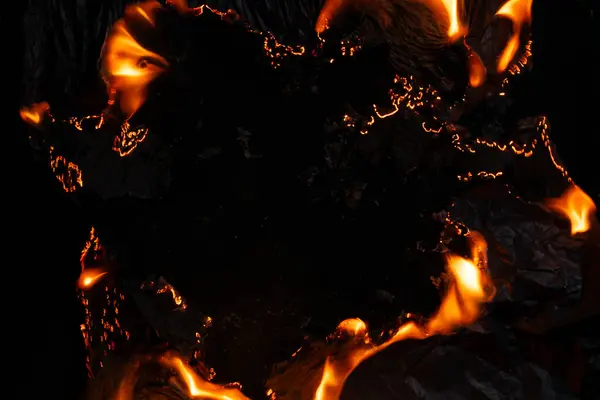 Yanan kağıt, parlayan kağıt kenarı siyah arkaplan üzerinde