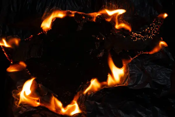 Yanan kağıt, parlayan kağıt kenarı siyah arkaplan üzerinde