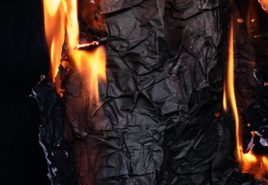 Kağıdı yakmak, siyah arka planda parlayan kağıt kenarı