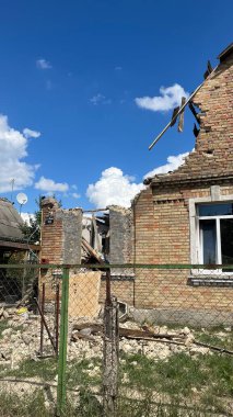 Hasarlı çatılı, kırık pencereli ev.