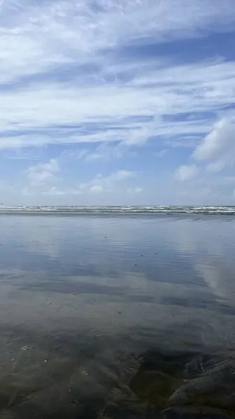 Güneş ışığının altında beyaz bulutlu bir denize yakın çekim. Duvar kağıtları ve arka planlar için mükemmel.