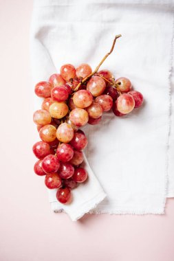 Pembe arka planda kırmızı üzümler, üst manzara..