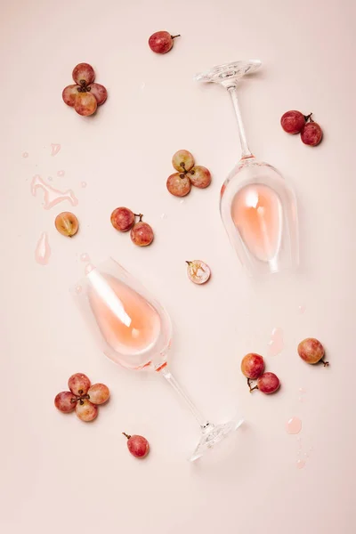 Two glasses of rose wine on a pink background, top view.