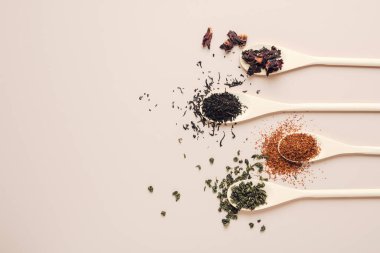 Açık arkaplanda çeşitli kurutulmuş çay yaprakları.