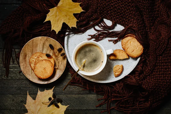 Cup of coffee with orange cookies, autumn cozy concept.