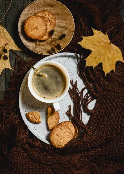 Cup of coffee with orange cookies, autumn cozy concept.