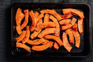 Baharatlı balkabağı dilimleri. Koyu arkaplan, üst görünüm..