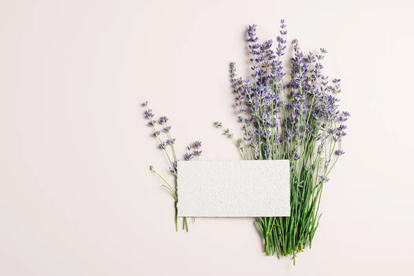 stock image Lavender flowers, homemade paper blank mockup on beige background.