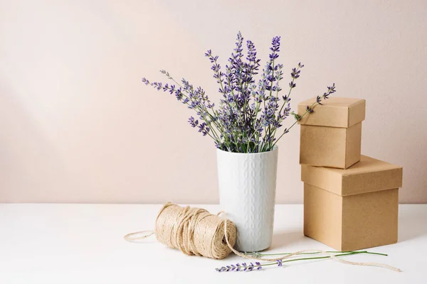 stock image Bouquet of lavender in a vase, two small gift boxes and jute thread, minimal eco style still life.