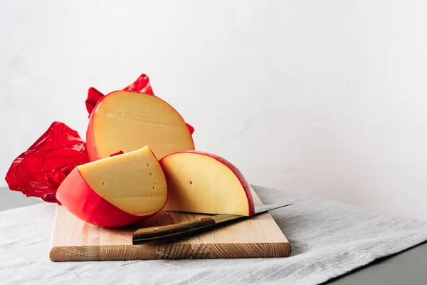 Dilimlenmiş Edam peyniri, kırmızı balmumu kaplamayla kaplı..