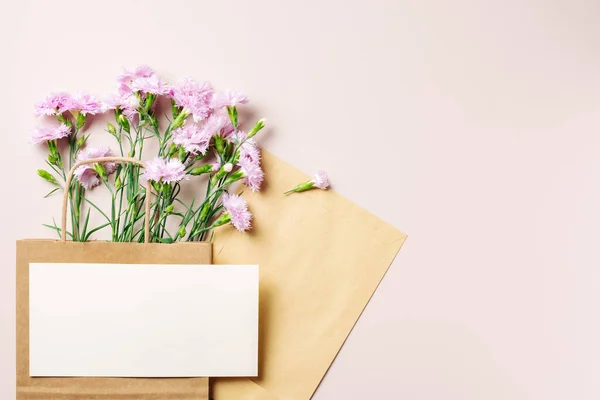 Kese kağıdındaki pembe karanfil çiçekleri, kart maketleri, uzay kopyaları..