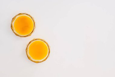 Hafif arka planda iki bardak portakal suyu. Asgari durağan yaşam, üst görünüm, kopyalama alanı.