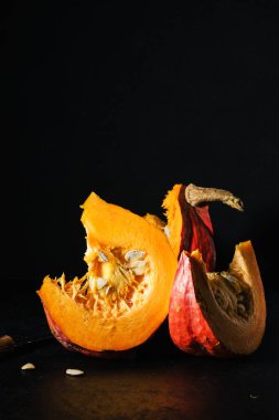 Siyah arka planda işlenmemiş balkabağı dilimleri.